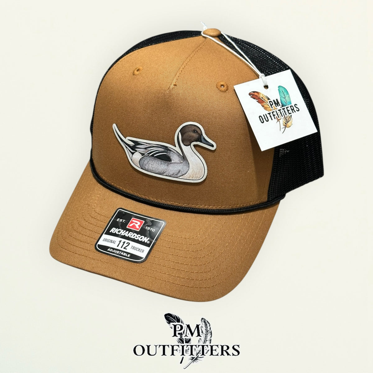 Hand-painted Northern Pintail trucker hat displayed with PM Outfitters branded hang tag