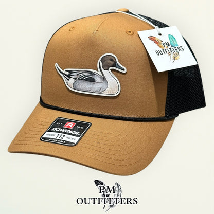 Back of the caramel and black Richardson 112 trucker hat showing the mesh panels and snapback closure, PM Outfitters True Originals