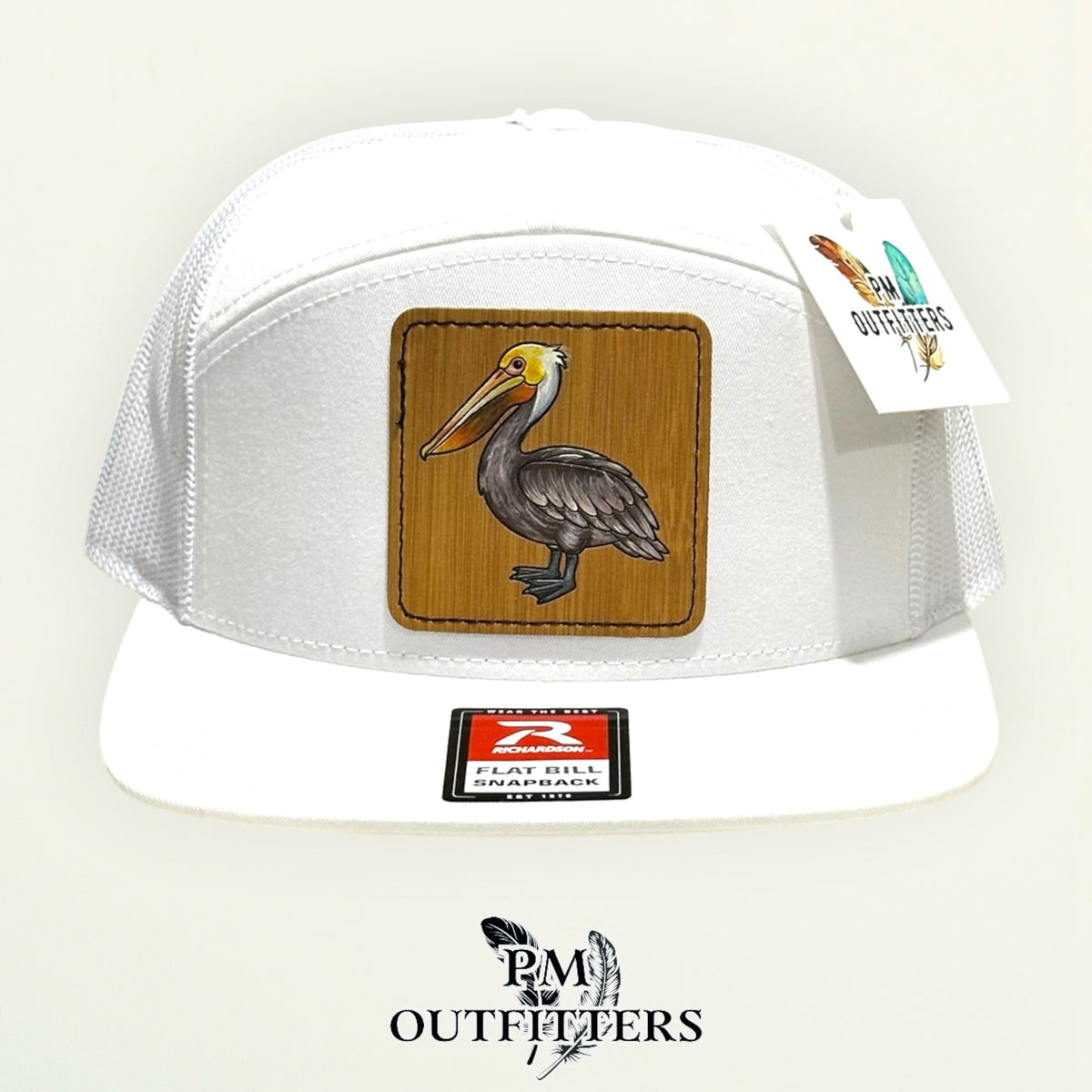 Hand-painted Brown Pelican patch on a white Richardson 168 flat-bill snapback hat, PM Outfitters True Originals