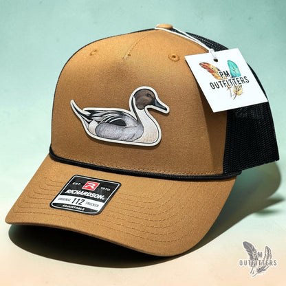 Hand-painted Northern Pintail patch on a caramel and black Richardson 112 trucker hat, PM Outfitters True Originals