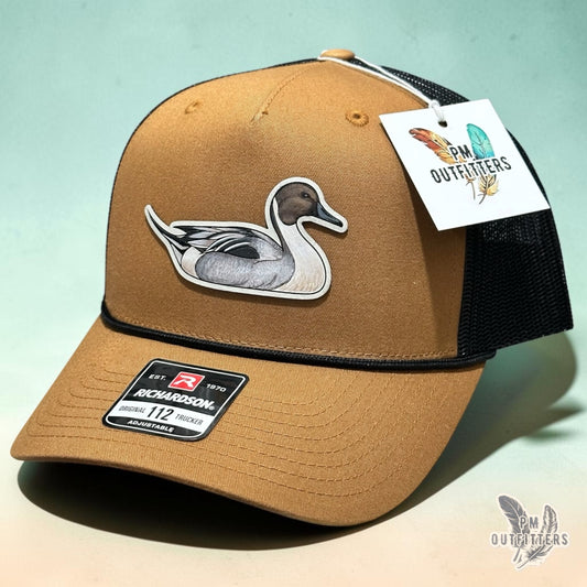 Hand-painted Northern Pintail patch on a caramel and black Richardson 112 trucker hat, PM Outfitters True Originals