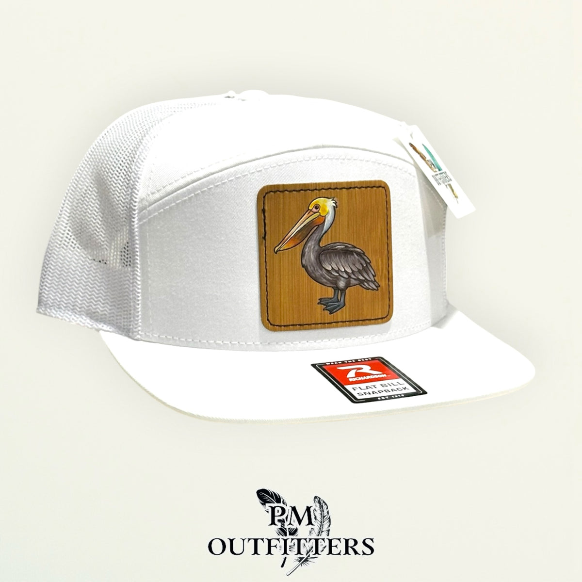 Hand-painted Brown Pelican patch on a white Richardson 168 flat-bill snapback hat, PM Outfitters True Originals