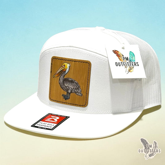 Hand-painted Brown Pelican patch on a white Richardson 168 flat-bill snapback hat, PM Outfitters True Originals
