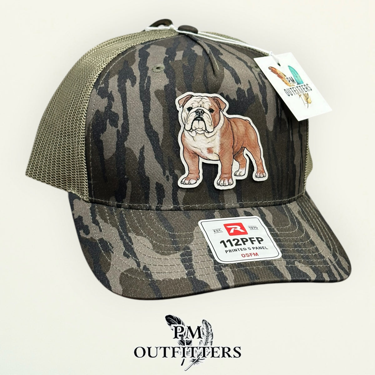 Mossy Oak Bottomland camo Richardson 112PFP trucker hat with hand-painted English Bulldog patch, angled view, PM Outfitters True Originals