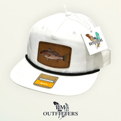 Hand-painted redfish performance rope cap displayed with PM Outfitters branded hang tag