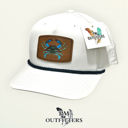 Hand-painted blue crab patch on a white Richardson 258 rope trucker hat with navy trim, PM Outfitters True Originals