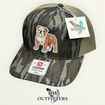 Hand-painted English Bulldog trucker hat displayed with PM Outfitters branded hang tag