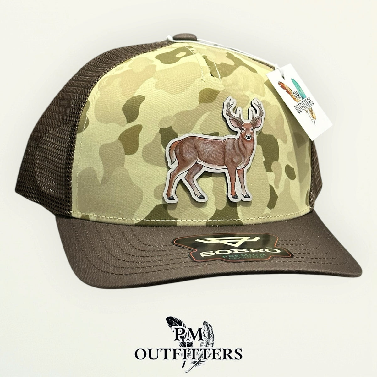 Ranchwood Camo trucker hat with brown mesh back and hand-painted deer patch, PM Outfitters True Originals