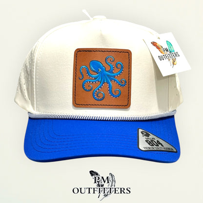 Side view of the hand-painted octopus patch on the cream and royal blue Dallas 804 rope cap, PM Outfitters True Originals