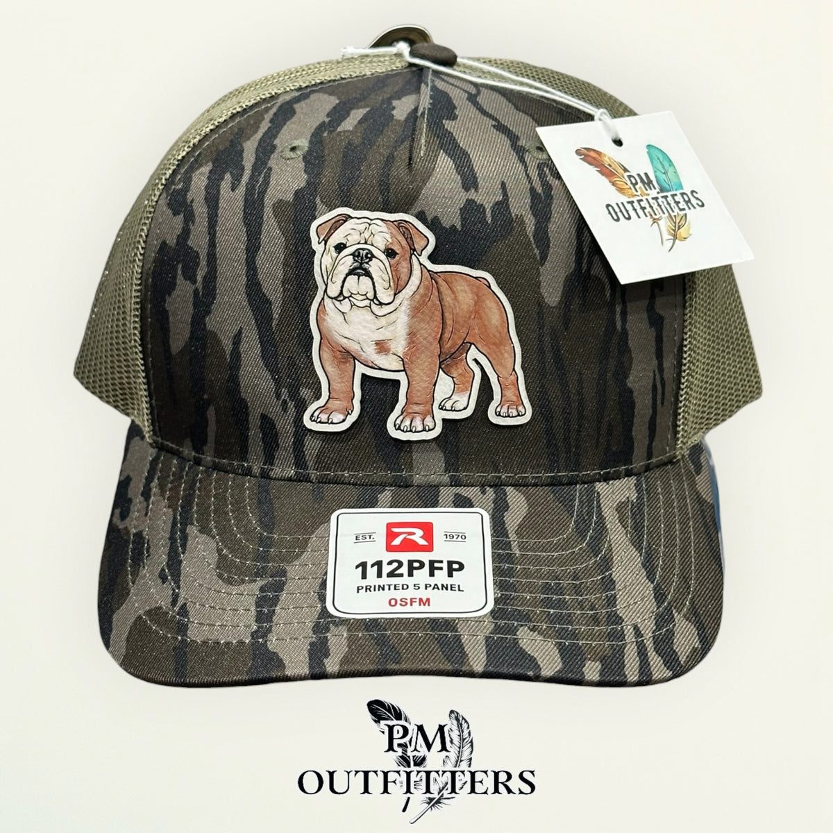 Side view of the hand-painted English Bulldog patch on the Mossy Oak Bottomland camo trucker hat, PM Outfitters True Originals