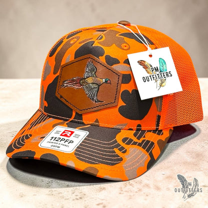 Hand-painted Pheasant patch on a blaze duck camo Richardson 112PFP trucker hat, PM Outfitters True Originals