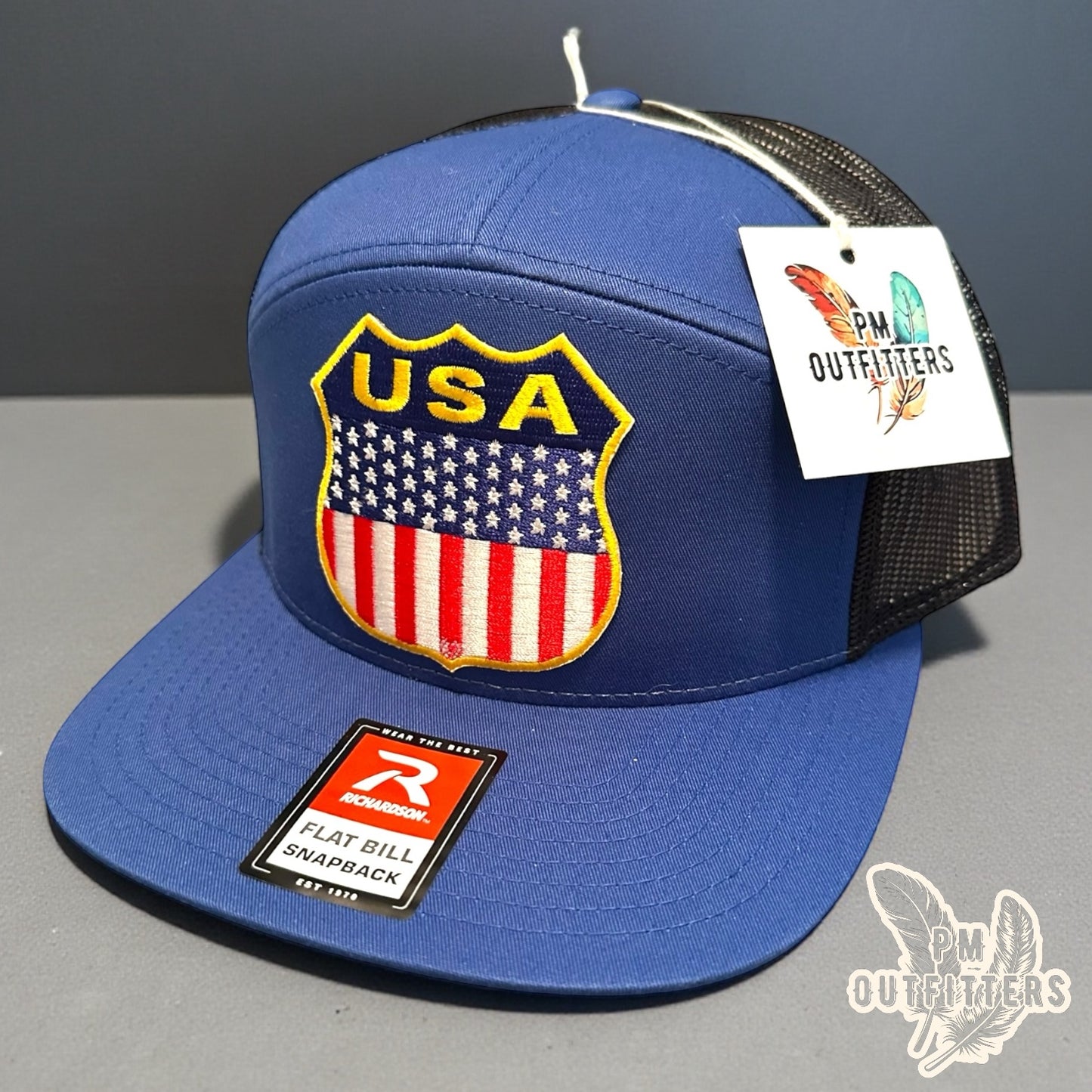 USA Shield Patch Trucker Hat — Retro American Flag Embroidered Patch | Richardson 168 7-Panel Flat Bill Blue Black