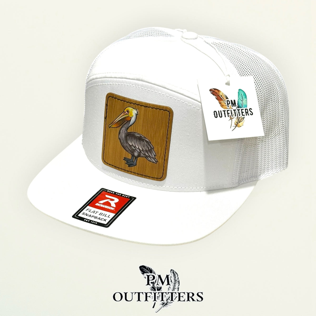 Hand-painted Brown Pelican patch on a white Richardson 168 flat-bill snapback hat, PM Outfitters True Originals