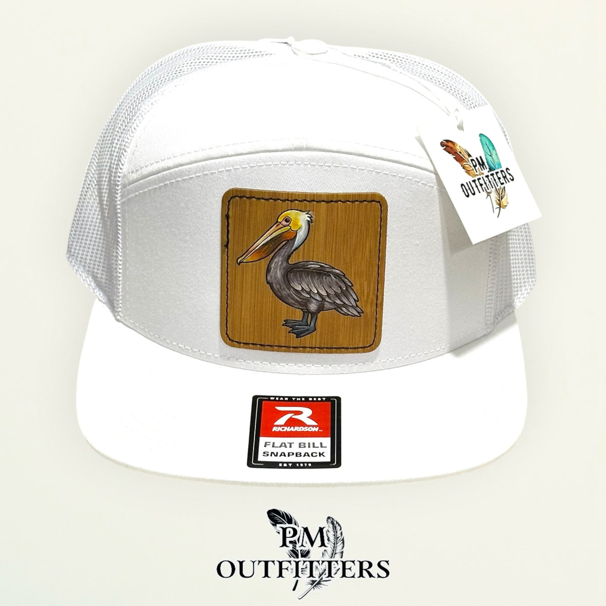 Hand-painted Brown Pelican patch on a white Richardson 168 flat-bill snapback hat, PM Outfitters True Originals