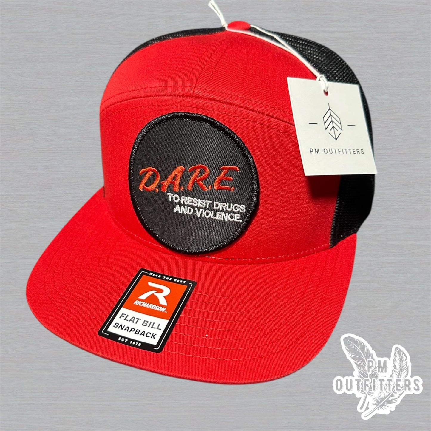 Red and black Richardson 168 7-panel trucker hat with retro DARE embroidered patch, vintage style.