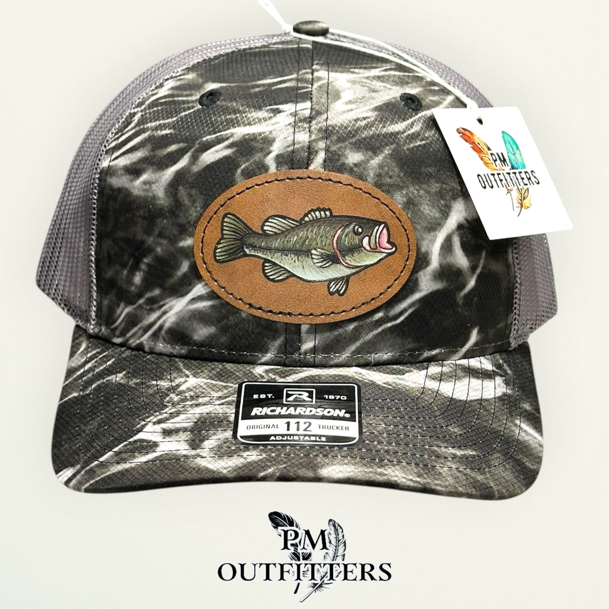 Side view of the hand-painted bass patch on the Mossy Oak Elements Blacktip camo trucker hat, PM Outfitters True Originals
