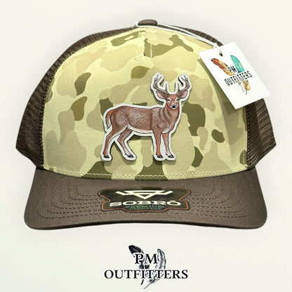 Sobro Waterwood Ranchwood Camo trucker hat with hand-painted whitetail buck patch, PM Outfitters True Originals