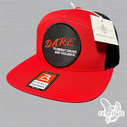 Red and black Richardson 168 7-panel trucker hat with retro DARE embroidered patch, vintage style.