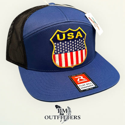 USA Shield Patch Trucker Hat — Retro American Flag Embroidered Patch | Richardson 168 7-Panel Flat Bill Blue Black