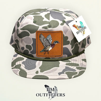 Hand-painted Wood Duck patch on a marsh duck camo Richardson 256P rope trucker hat, PM Outfitters True Originals