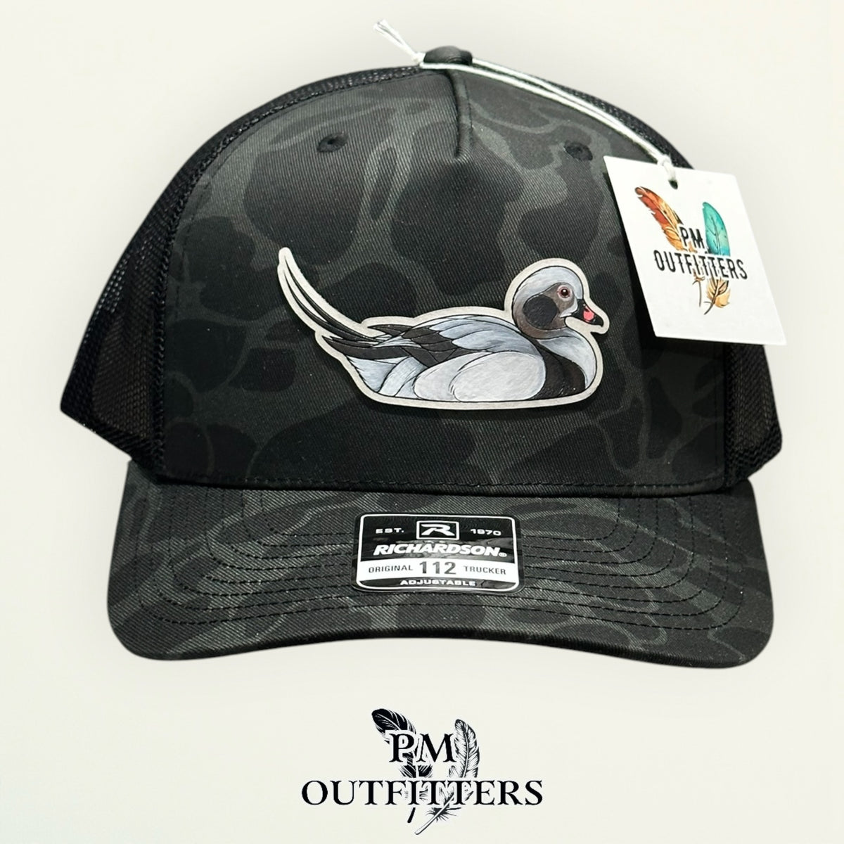 Side view of the hand-painted Long-Tailed Duck patch on the Sable duck camo trucker hat, PM Outfitters True Originals