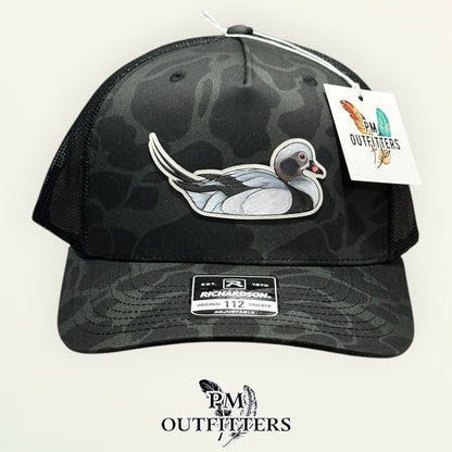 Side view of the hand-painted Long-Tailed Duck patch on the Sable duck camo trucker hat, PM Outfitters True Originals