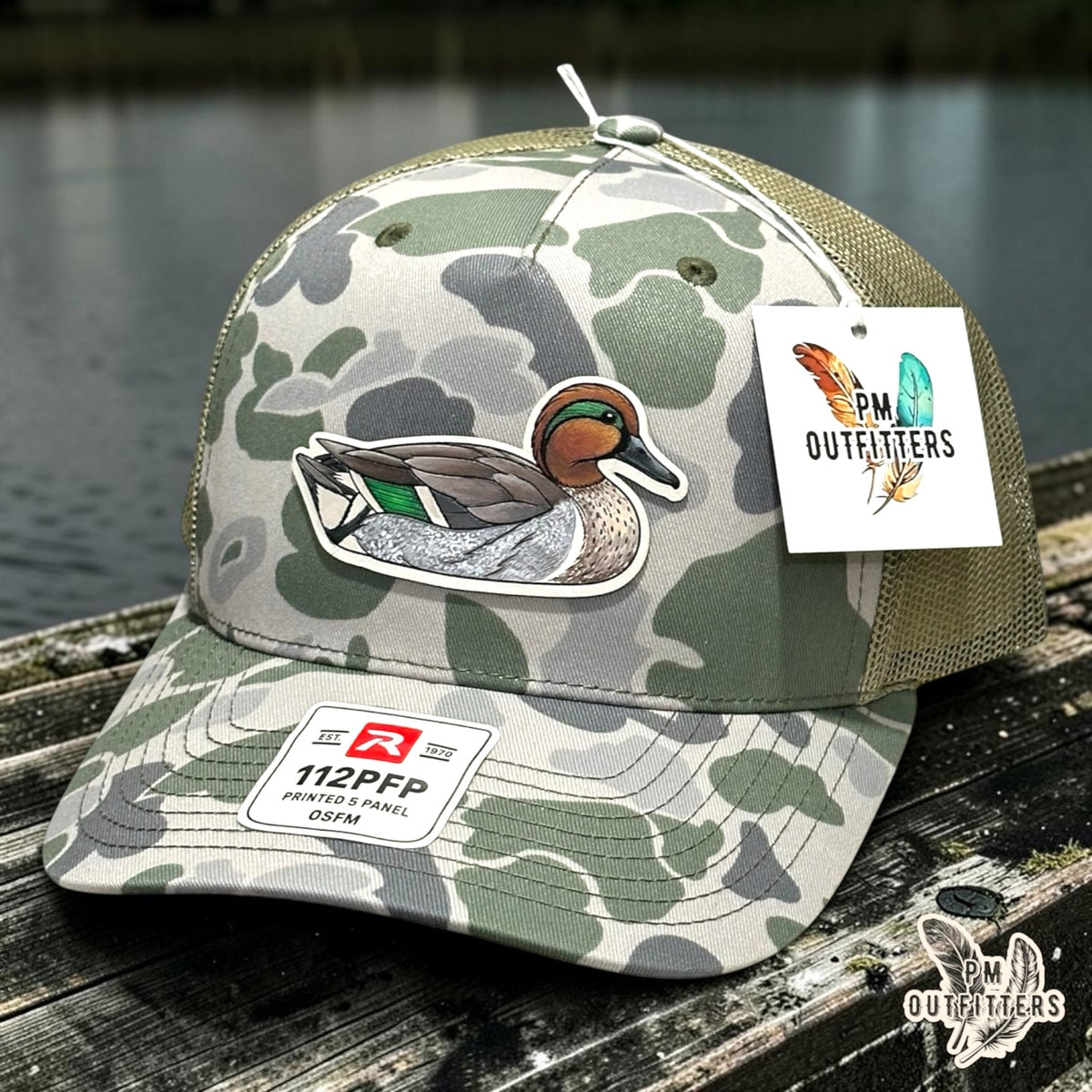 Hand-painted Green-Winged Teal patch on a Richardson 112PFP Marsh duck camo trucker hat, PM Outfitters True Originals
