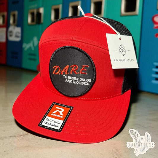 Red and black Richardson 168 7-panel trucker hat with retro DARE embroidered patch, vintage style.