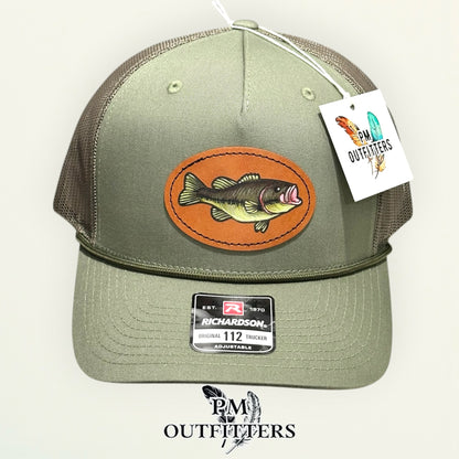 Side view of the hand-painted bass patch on the loden green Richardson 112 trucker hat, PM Outfitters True Originals