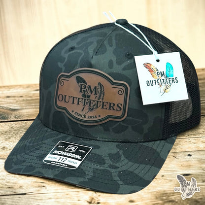 PM Outfitters signature logo trucker hat Sable Duck camo Richardson 112 vegan leather patch