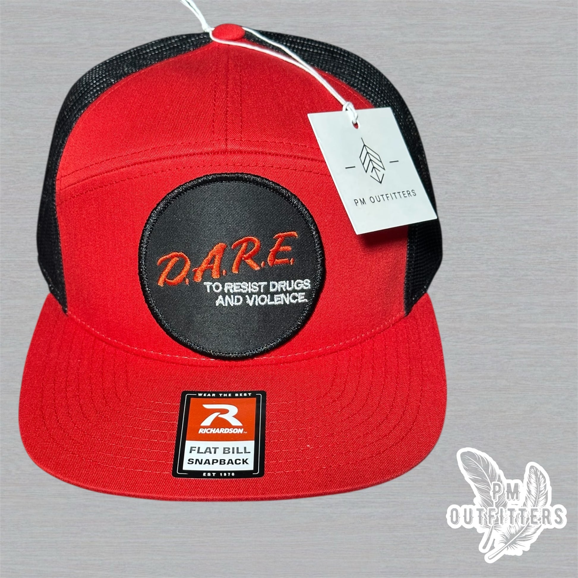 Red and black Richardson 168 7-panel trucker hat with retro DARE embroidered patch, vintage style.