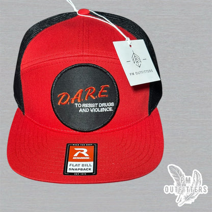 Red and black Richardson 168 7-panel trucker hat with retro DARE embroidered patch, vintage style.