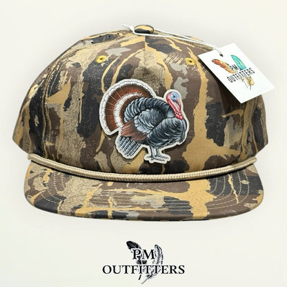 Sobro Marina Pro Perforated Burnt Umber HuntLand camo rope hat with hand-painted turkey patch, PM Outfitters True Originals