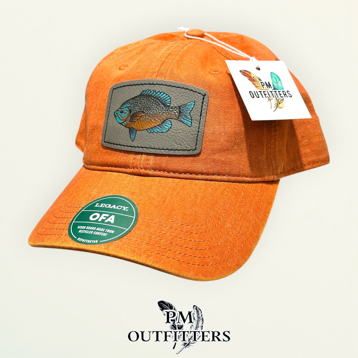 Hand-painted longear sunfish patch on a burnt orange Legacy garment-washed cap, PM Outfitters True Originals