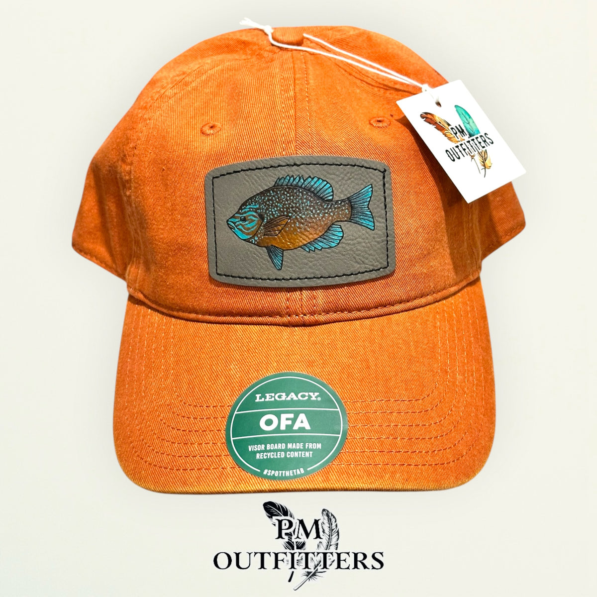 Hand-painted longear sunfish patch on a burnt orange Legacy garment-washed cap, PM Outfitters True Originals