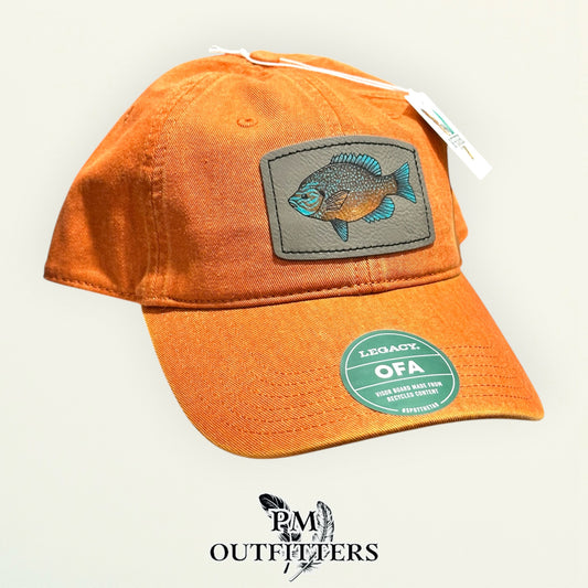 Hand-painted longear sunfish patch on a burnt orange Legacy garment-washed cap, PM Outfitters True Originals