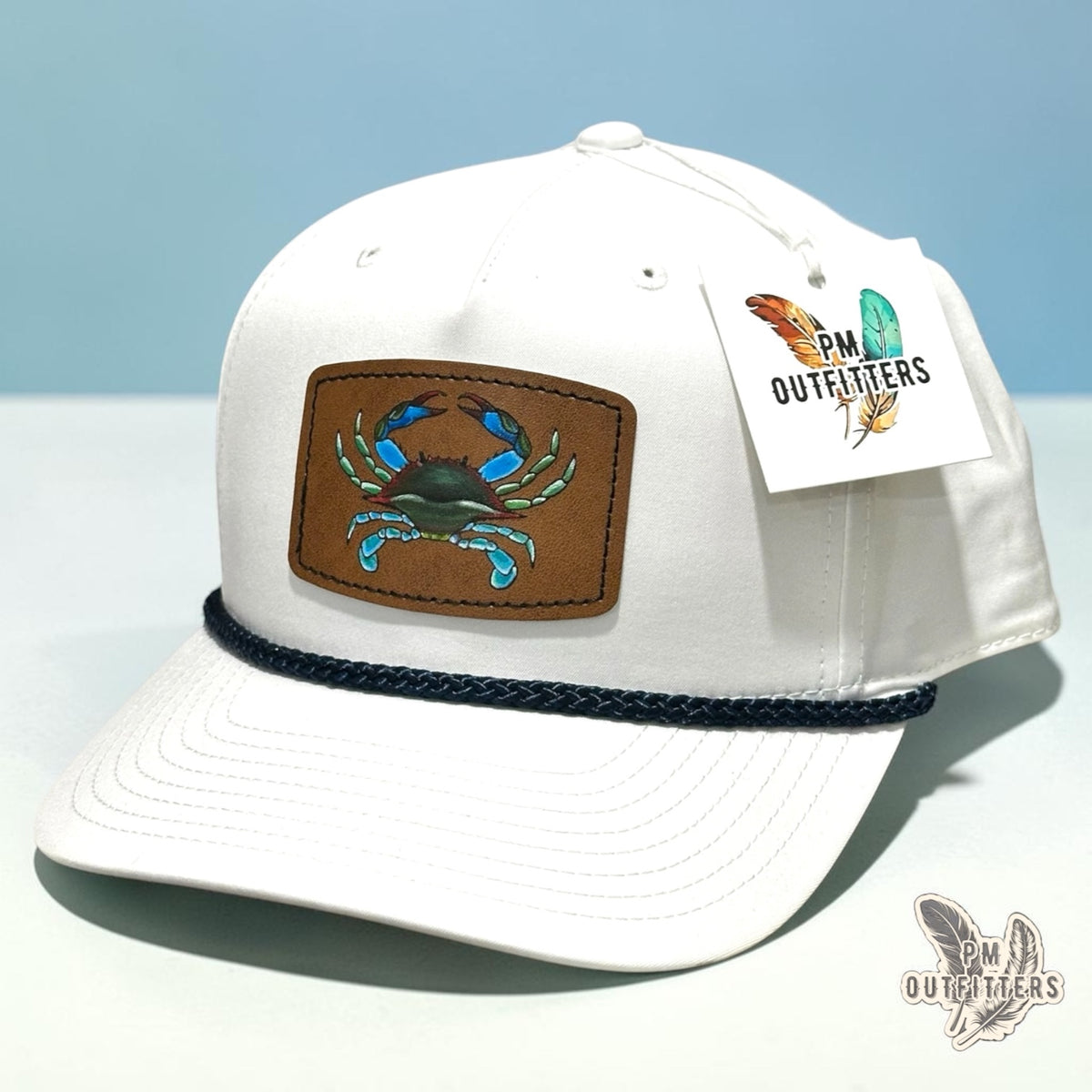 Hand-painted blue crab patch on a white Richardson 258 rope trucker hat with navy trim, PM Outfitters True Originals