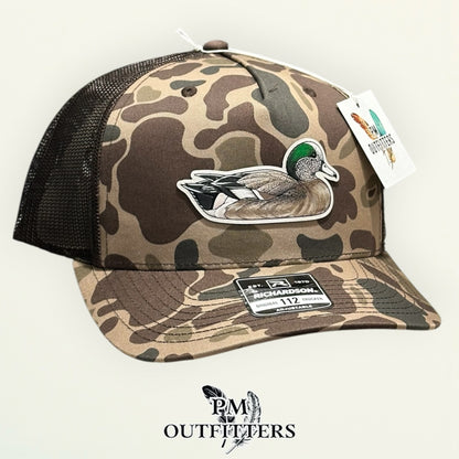 Bark duck camo Richardson 112PFP trucker hat with hand-painted American Wigeon patch, angled view, PM Outfitters True Originals