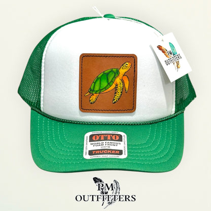 Side view of the hand-painted sea turtle patch on the white and green Otto trucker hat, PM Outfitters True Originals