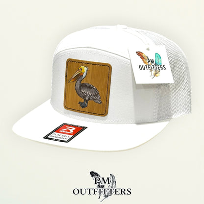Hand-painted Brown Pelican patch on a white Richardson 168 flat-bill snapback hat, PM Outfitters True Originals