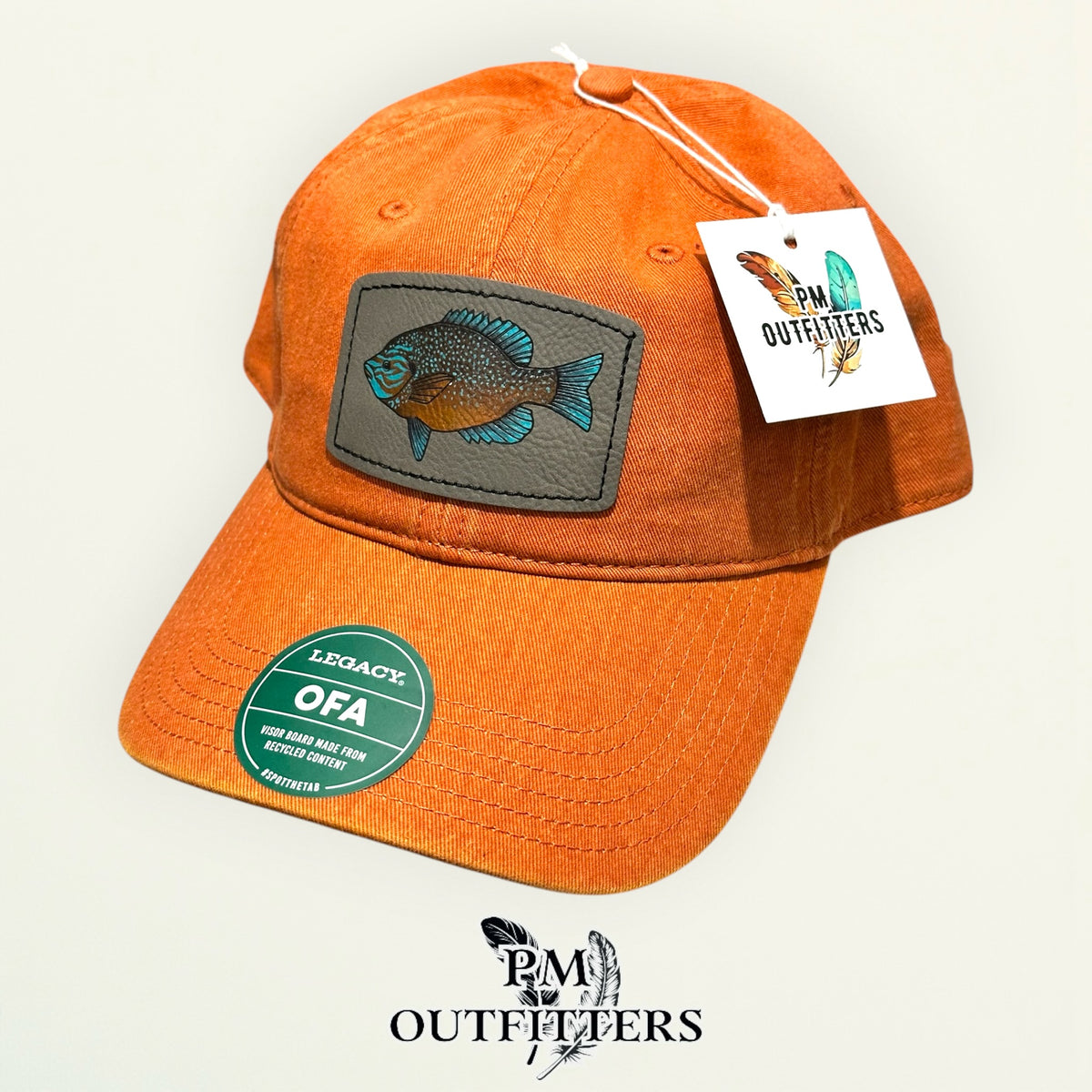 Hand-painted longear sunfish patch on a burnt orange Legacy garment-washed cap, PM Outfitters True Originals
