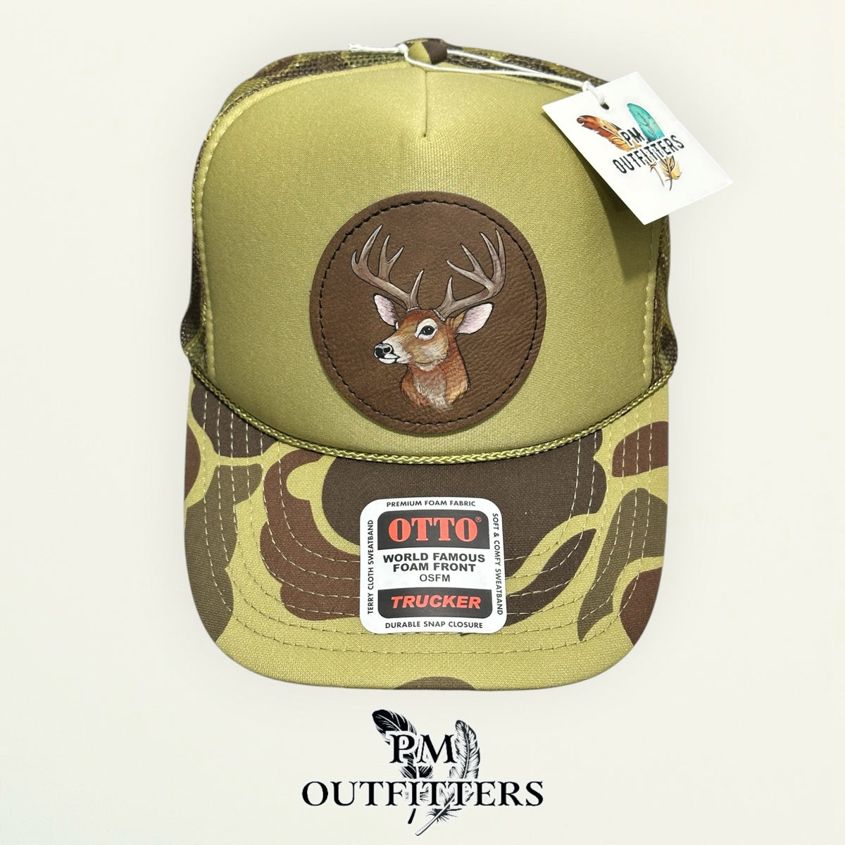 Olive green and camo Otto trucker hat with hand-painted whitetail buck patch, PM Outfitters True Originals