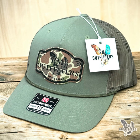 PM Outfitters signature logo rope trucker hat loden green Richardson 112 camo vegan leather patch