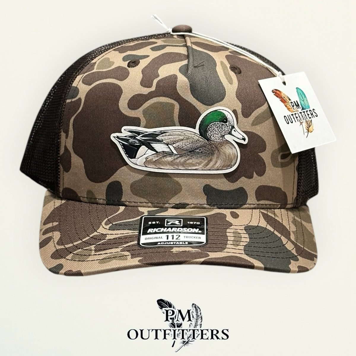 Side view of the hand-painted American Wigeon patch on the Bark duck camo trucker hat, PM Outfitters True Originals