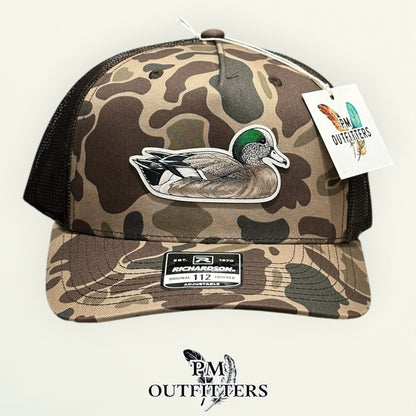 Side view of the hand-painted American Wigeon patch on the Bark duck camo trucker hat, PM Outfitters True Originals