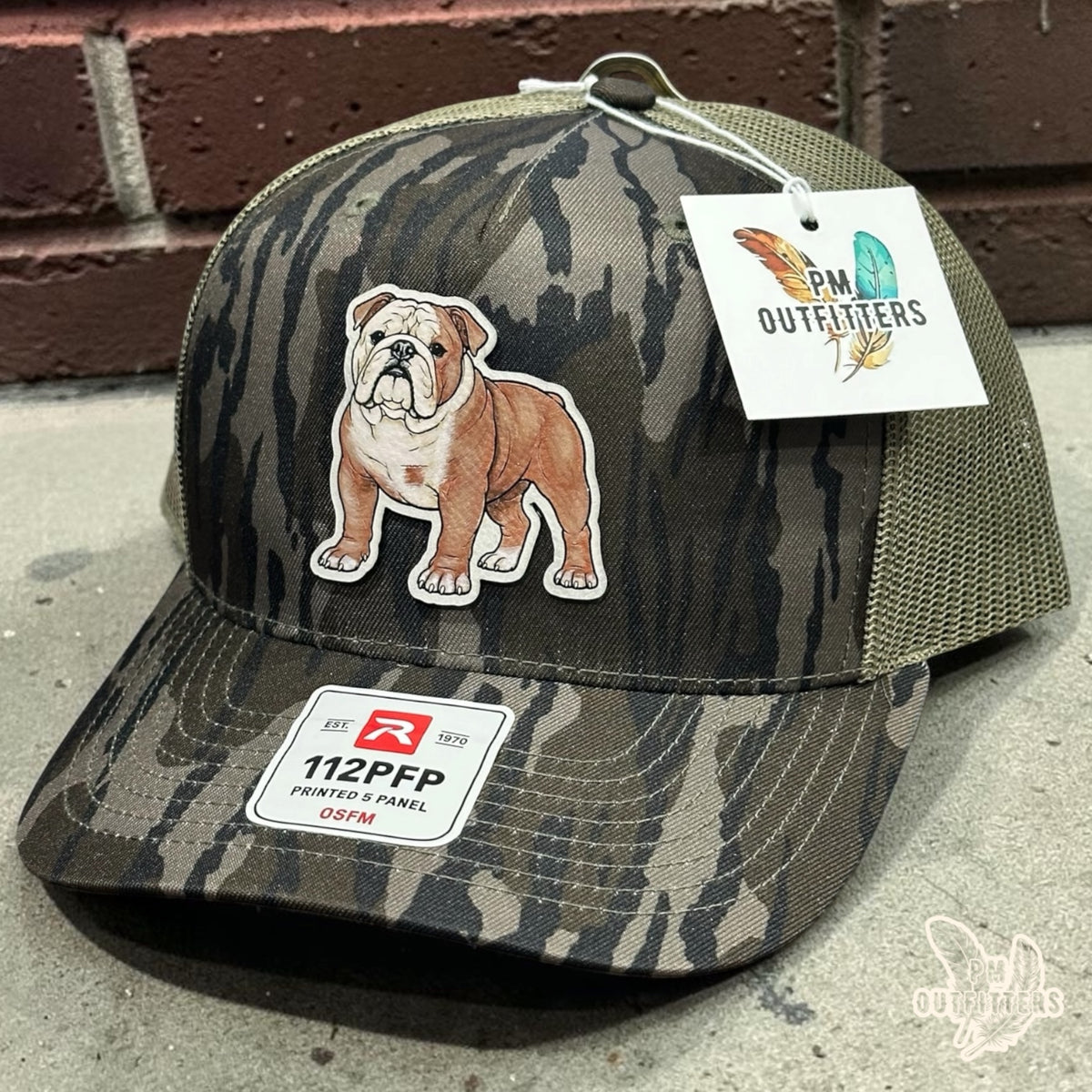 Hand-painted English Bulldog patch on a Richardson 112PFP trucker hat in Mossy Oak Bottomland camo, PM Outfitters True Originals