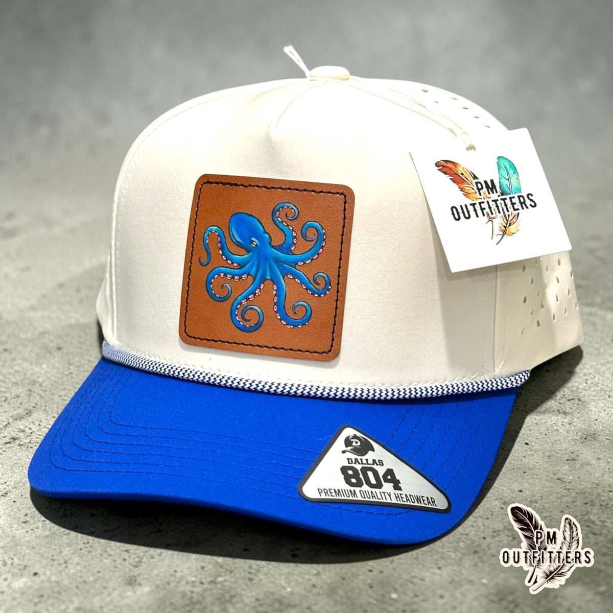 Hand-painted octopus patch on a cream and royal blue Dallas 804 performance rope cap, PM Outfitters True Originals