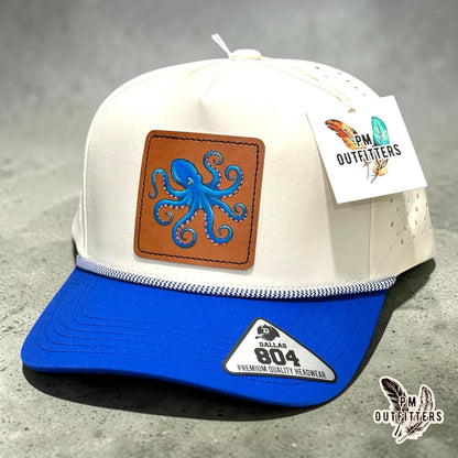 Hand-painted octopus patch on a cream and royal blue Dallas 804 performance rope cap, PM Outfitters True Originals