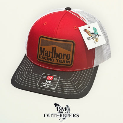 PM Outfitters Marlboro Racing Team trucker hat red black white Richardson 112 tan vegan leather patch front three-quarter view