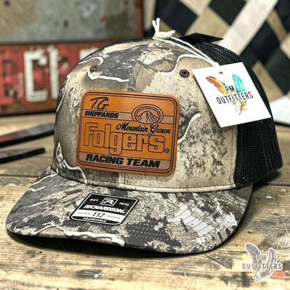 TG Sheppard Folgers Racing Team custom laser-engraved leatherette patch on Richardson 112 Realtree Excape camo and black mesh trucker hat, featured view